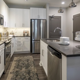 Kitchen Spacious and well lit kitchen with wood flooring and stainless steel appliances