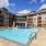 Large sparkling blue pool with a large pool deck and lounge chairs